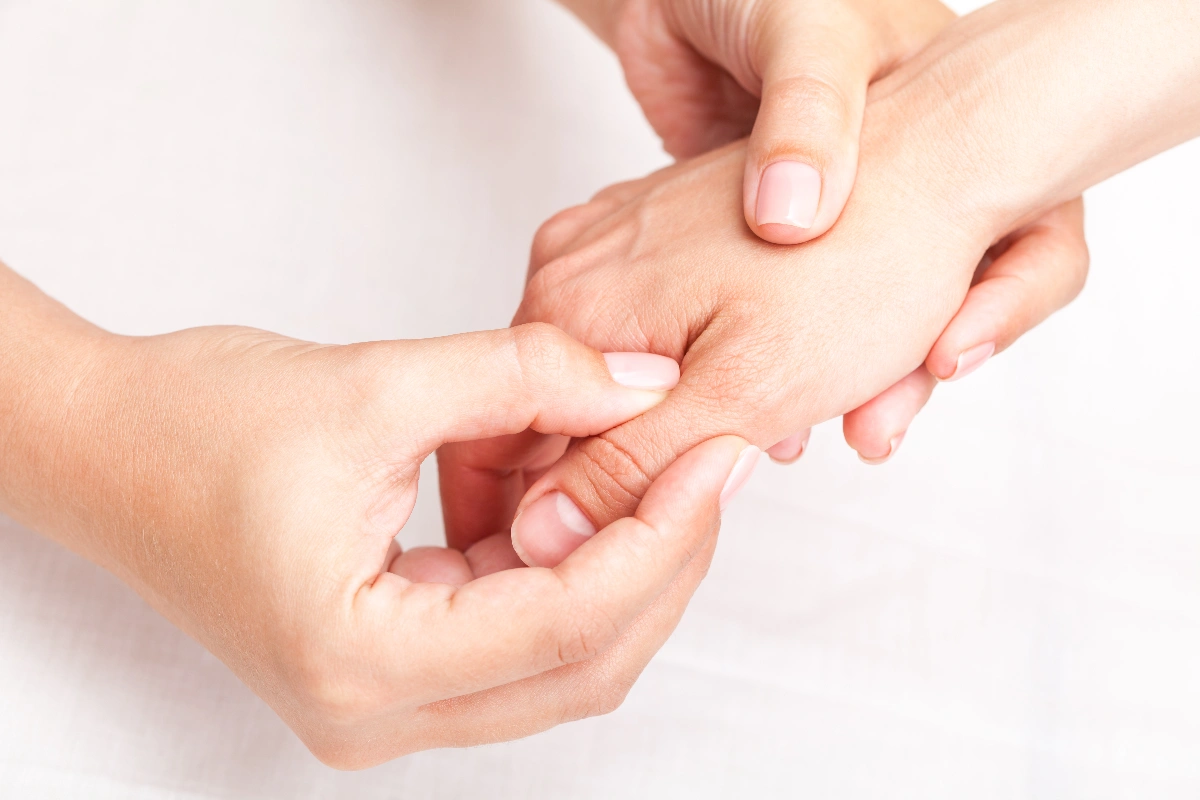 Two hands gently massaging another hand against a soft white background, conveying a sense of relaxation and care. Close-up, emphasis on touch. Hand & Finger Joint Replacement Dr. Rod French Vancouver