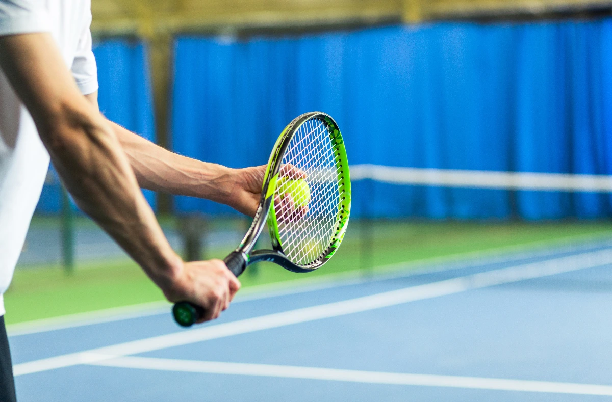 Athlete holding tennis racket, ready to serve. Hand Surgeon for Athletes Dr. Rod French Vancouver, BC
